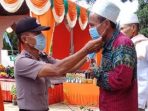 Aparatur Polsek Besitang masangkan masker kepada warga di tengah pesta