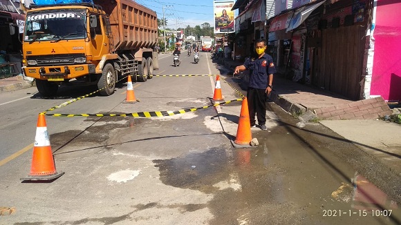 Badan jalan yang ditambal oleh Personil Polres Samosir