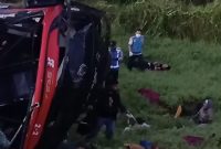 Kondisi Bus Halmahera yang terbalik dan rusak parah di luar jalur tol KM 63,2 Tol Jasa Marga Kualanamu (JMKT), Desa Sei Sejenggi, Kecamatan Perbaungan, Senin (11/5/2026). Di lokasi terlihat petugas dan warga sedang melakukan evakuasi korban kecelakaan yang mengakibatkan empat orang meninggal dunia. Foto: Ist.