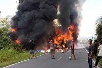 Kondisi lokasi kecelakaan maut antara bus ALS dan truk tangki di Jalan Lintas Sumatera, Kabupaten Musi Rawas Utara (Muratara). Terlihat kedua kendaraan terbakar hebat disertai asap hitam tebal menyembul ke udara, sejumlah warga tampak berkumpul di sekitar lokasi menyaksikan kejadian naas tersebut. Foto: Ist.