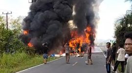 Kondisi lokasi kecelakaan maut antara bus ALS dan truk tangki di Jalan Lintas Sumatera, Kabupaten Musi Rawas Utara (Muratara). Terlihat kedua kendaraan terbakar hebat disertai asap hitam tebal menyembul ke udara, sejumlah warga tampak berkumpul di sekitar lokasi menyaksikan kejadian naas tersebut. Foto: Ist.