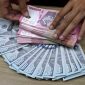 Petugas memperlihatkan uang rupiah dan dolar Amerika Serikat di tengah penguatan kurs dolar AS yang menembus level Rp 17.800 terhadap rupiah, Kamis (28/5/2026). Foto: Ist.