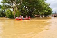 Tim gabungan menggunakan perahu karet saat melakukan proses evakuasi warga di wilayah yang terendam banjir akibat meluapnya sungai di Kabupaten Nagan Raya, Aceh. Air bah berwarna keruh terlihat menggenangi jalan dan pemukiman, mengganggu aktivitas masyarakat serta memutus akses transportasi. Foto: Ist.
