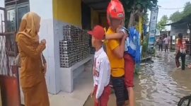 Suasana di depan SD Negeri 165726 Jalan Jenderal Sudirman, Kota Tebingtinggi, yang terendam banjir akibat meluapnya Sungai Padang. Terlihat para siswa sedang dijemput dan dievakuasi oleh orang tua atau warga karena kegiatan belajar mengajar terpaksa diliburkan demi keselamatan. Foto: Ist.