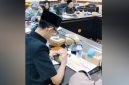 Achmad Syahri Assidiqi, anggota DPRD Jember dari Partai Gerindra, terlihat asyik menunduk memainkan ponsel diduga bermain gim sambil merokok di meja sidang saat rapat Komisi D bersama Dinas Kesehatan membahas penanganan stunting. Foto: Ist.
