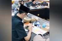 Achmad Syahri Assidiqi, anggota DPRD Jember dari Partai Gerindra, terlihat asyik menunduk memainkan ponsel diduga bermain gim sambil merokok di meja sidang saat rapat Komisi D bersama Dinas Kesehatan membahas penanganan stunting. Foto: Ist.