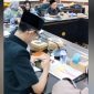 Achmad Syahri Assidiqi, anggota DPRD Jember dari Partai Gerindra, terlihat asyik menunduk memainkan ponsel diduga bermain gim sambil merokok di meja sidang saat rapat Komisi D bersama Dinas Kesehatan membahas penanganan stunting. Foto: Ist.