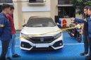 Petugas kepolisian melakukan pemeriksaan dan pengamanan terhadap mobil Honda Civic Turbo warna putih milik Kepala Desa Purwasaba (Kades Hoho) yang dibakar di Kabupaten Banjarnegara. Foto: Ist.
