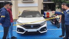 Petugas kepolisian melakukan pemeriksaan dan pengamanan terhadap mobil Honda Civic Turbo warna putih milik Kepala Desa Purwasaba (Kades Hoho) yang dibakar di Kabupaten Banjarnegara. Foto: Ist.