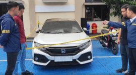 Petugas kepolisian melakukan pemeriksaan dan pengamanan terhadap mobil Honda Civic Turbo warna putih milik Kepala Desa Purwasaba (Kades Hoho) yang dibakar di Kabupaten Banjarnegara. Foto: Ist.