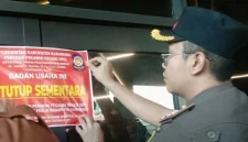 Petugas Satuan Polisi Pamong Praja (Satpol PP) Kabupaten Karawang memasang stiker pemberitahuan penutupan sementara pada lokasi Karawang Theatre Night Mart, Selasa (9/6/2026). Foto: Ist.