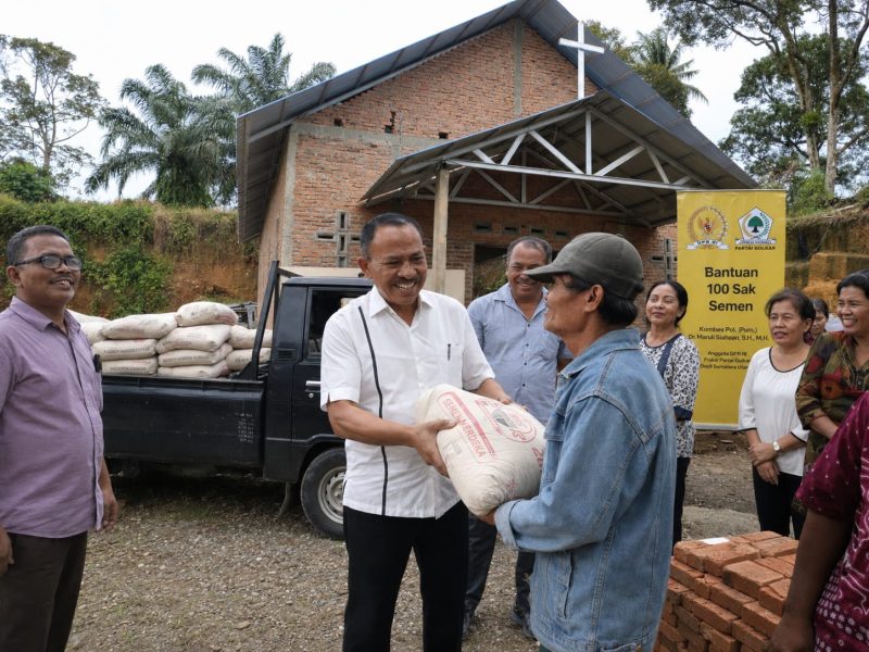 Anggota DPR RI Komisi XIII Dr Maruli Siahaan SH MH menyerahkan bantuan berupa semen untuk pembangunan  HKBP Nazareth Pancurbatu, Rabu (24/6).(ist)