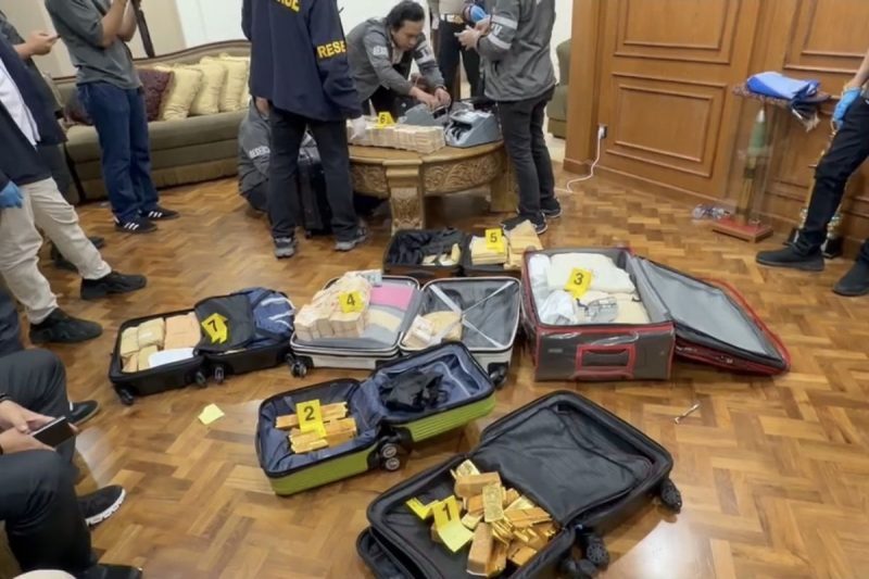 Polisi sedang menghitung jumlah emas batangan dan uang tunai dari dalam kawasan Sentul, Kecamatan Babakan Madang, Kabupaten Bogor. Foto: Ist.