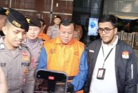 Bupati Kuantan Singingi Suhardiman Amby mengenakan rompi tahanan, didampingi petugas kepolisian dan penyidik KPK.  Foto: Ist.