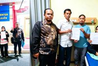 Staf Tata Usaha MTsN 1 Asahan, Rini Siregar, didampingi tim kuasa hukum menunjukkan dokumen laporan dugaan ancaman yang dialaminya setelah mengunggah temuan buah naga berulat dalam menu Program Makan Bergizi Gratis. Foto: IAS.