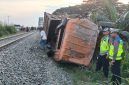 Kondisi truk Mitsubishi yang hancur dan terbalik di samping rel kereta api setelah ditabrak KA Putri Deli di pelintasan sebidang tanpa palang pengaman di Perbaungan, Serdang Bedagai, Minggu (2/8/2026). Kecelakaan itu menewaskan sopir truk dan menyebabkan lokomotif kereta sempat anjlok keluar jalur. Foto: Ist.