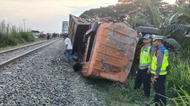 Kondisi truk Mitsubishi yang hancur dan terbalik di samping rel kereta api setelah ditabrak KA Putri Deli di pelintasan sebidang tanpa palang pengaman di Perbaungan, Serdang Bedagai, Minggu (2/8/2026). Kecelakaan itu menewaskan sopir truk dan menyebabkan lokomotif kereta sempat anjlok keluar jalur. Foto: Ist.