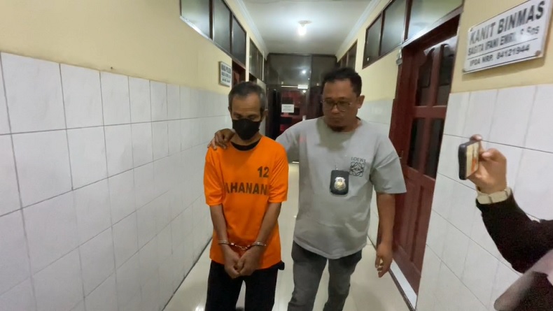 Tersangka Mudasir, Sekretaris Dinas Peternakan Labuhanbatu, didampingi petugas kepolisian setelah ditangkap terkait dugaan penipuan bermodus proyek pengadaan laptop fiktif yang merugikan puluhan orang dengan kerugian mendekati Rp1 miliar. Foto: Ist.