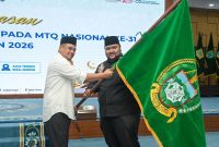Gubernur Sumut Bobby Nasution menyerahkan pataka bendera Sumatera Utara secara simbolis kepada Ketua Kafilah MTQ Sumut M. Yasir Tanjung pada acara pelepasan kontingen MTQ Nasional ke-31 di Aula Tengku Rizal Nurdin, Medan, Selasa (8/9/2026). Foto: Ist.
