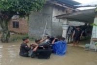 Sejumlah warga berusaha menyeberangkan dan menyelamatkan sepeda motor menerjang genangan banjir yang merendam pemukiman penduduk di Sumatera Utara. Foto: Ist.