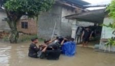 Sejumlah warga berusaha menyeberangkan dan menyelamatkan sepeda motor menerjang genangan banjir yang merendam pemukiman penduduk di Sumatera Utara. Foto: Ist.