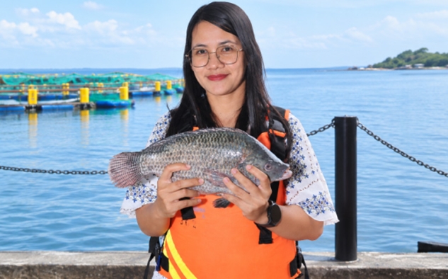 Friska Setiawani Saragih, Lake Manager Regal Springs Indonesia, menampilkan ikan tilapia hasil budidaya berkelanjutan di Danau Toba. Ia memimpin pengembangan varian KING Tilapia premium sekaligus menjaga standar kualitas air dan ekosistem agar produk Indonesia dapat bersaing di pasar global. Foto: Ist.