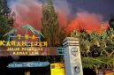 Kobaran api karhutla tampak menyala terang di balik papan penanda jalur pendakian Taman Wisata Alam Kawah Ijen, Sabtu (5/9/2026).