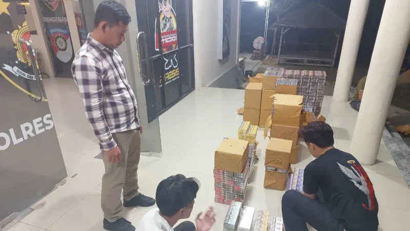 Petugas Polres Mesuji menata barang bukti rokok ilegal 118.400 batang senilai Rp88,3 juta hasil penggerebekan di Desa Panca Warna, Way Serdang. Satu tersangka diamankan, pemasok dari Tulang Bawang Barat diburu, Kamis (8/10/2026). Foto: Ist.