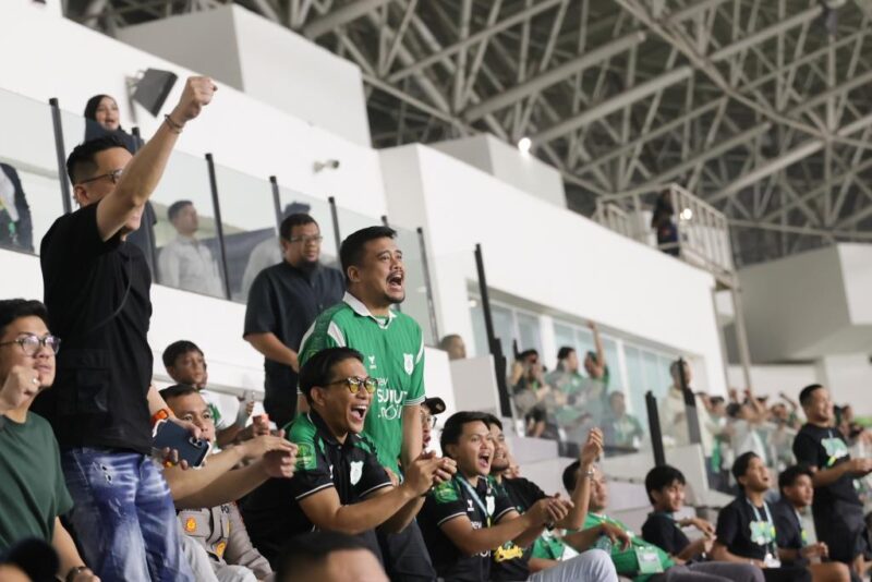 Gubernur Sumatera Utara, Muhammad Bobby Afif Nasution (tengah mengenakan jersi hijau), bersorak antusias saat menyaksikan langsung laga PSMS Medan melawan PSIS Semarang di tribun Stadion Utama Sumatera Utara, Deliserdang. Foto: Ist.