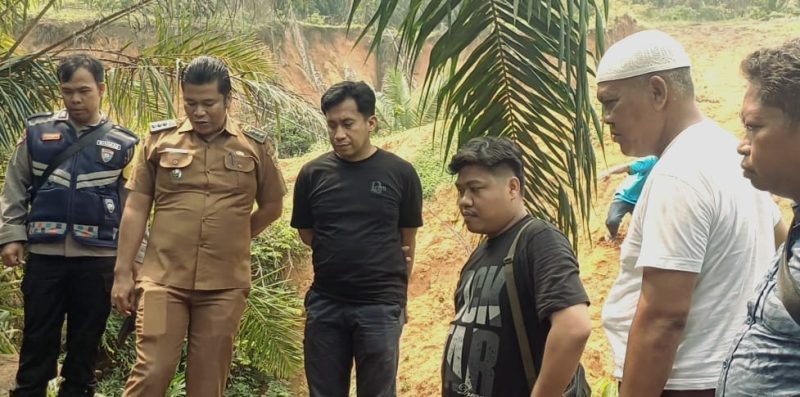 Camat Sungaikanan, Yusran Hasian Harahap SE MM (dua kiri), Perwakilan Kebun B Simangunsong (tiga kanan), Tokoh masyarakat H Kodirun Harahap SH (dua kanan) bersama jajaran Polsek Sungaikanan dan Personel Koramil 12/Langgapayung saat meninjau langsung longsor hebat sudut Kebun B di Desa Sabungan, Sungaikanan, Labusel, kemarin. Foto: D|maruli siregar