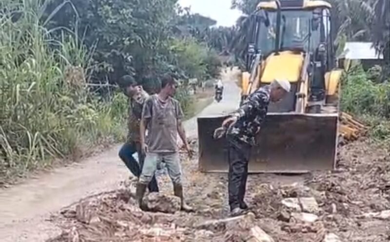 Bukti antusias, warga yang melintas di Kampung Jawa, Jalan Kabupaten penghubung Simpang Torpa Langgapayung-Aektinga, Kec. Sungaikanan, Labusel, Kamis (29/10), turut membantu saat alat berat milik PT STA memperbaiki jalan yang sejak lama bagai kubangan dan mengeruk beram jalan yang ditumbuhi belukar. Foto: ist